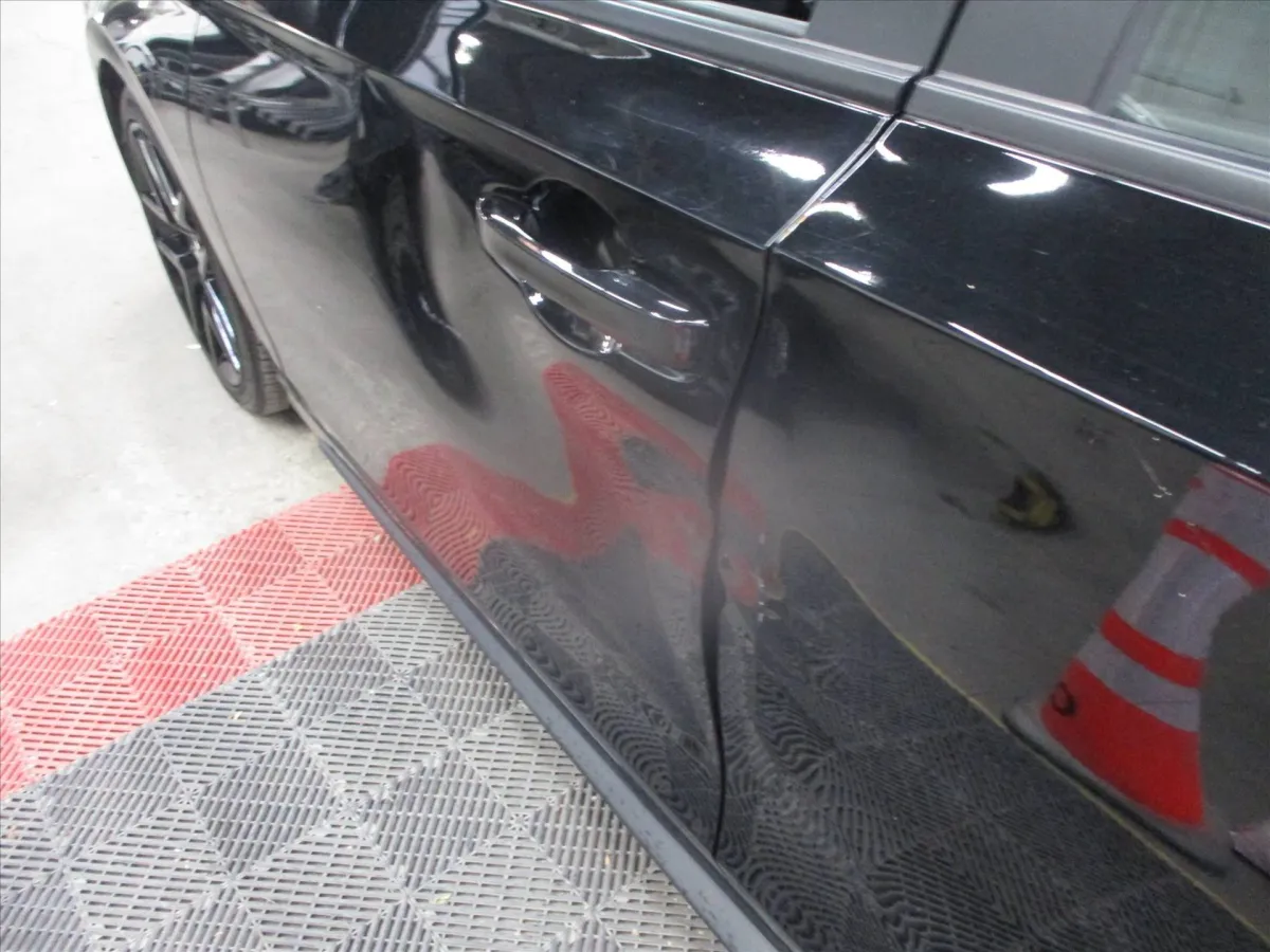Door crease damage on a black Honda Civic